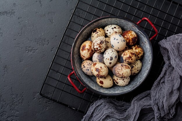 Oeufs de caille en plaque de métal sur une vieille surface sombre. Style rustique