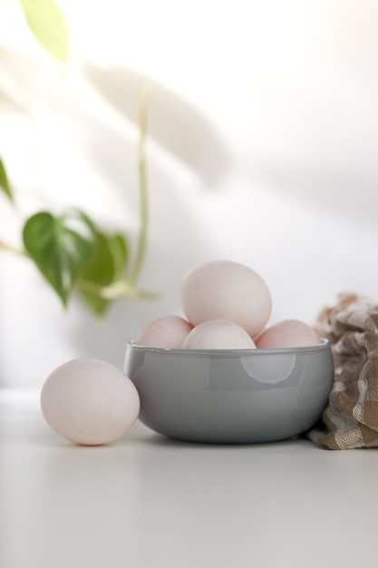 Les oeufs de canard dans un bol gris sur une table en bois blanche