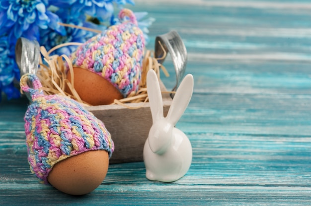 Oeufs en chapeaux tricotés, fleurs et lapin décoratif