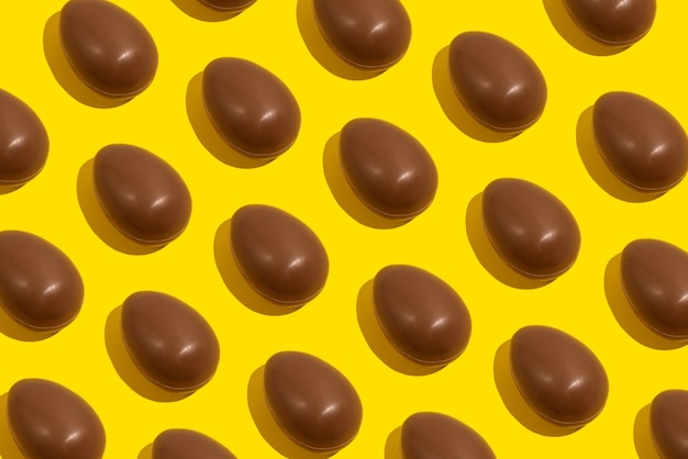 Oeufs en chocolat Modèle sans couture d'oeufs en chocolat entiers sur fond jaune