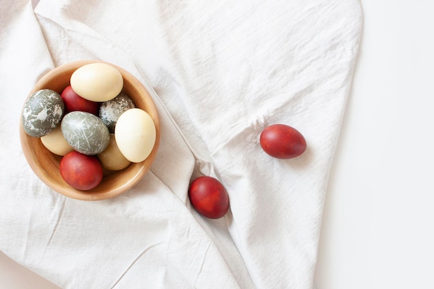 Oeufs colorés de fond rustique sur un fond tissé de Pâques