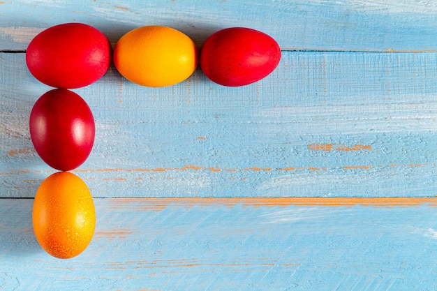 Oeufs colorés pour Pâques sur un fond en bois bleu avec espace copie