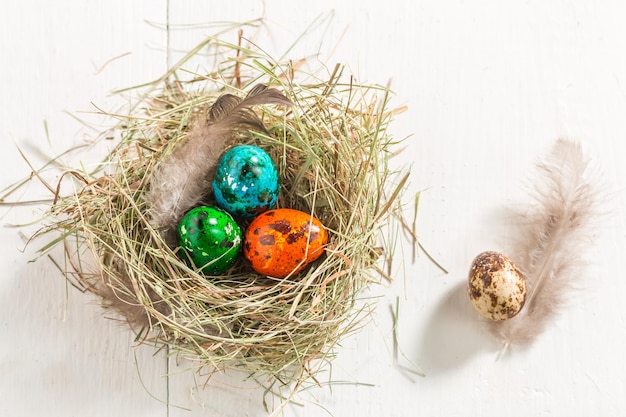 Oeufs colorés pour Pâques sur une vieille table blanche