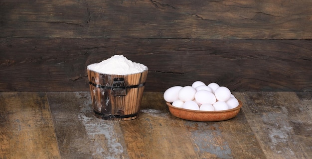 oeufs crus dans une assiette en bois sur un fond en bois