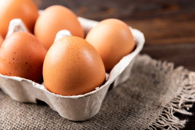 Oeufs crus sur une table en bois sombre