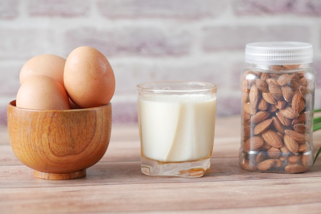 Oeufs dans un arc de noix d'amande et un verre de lait sur la table