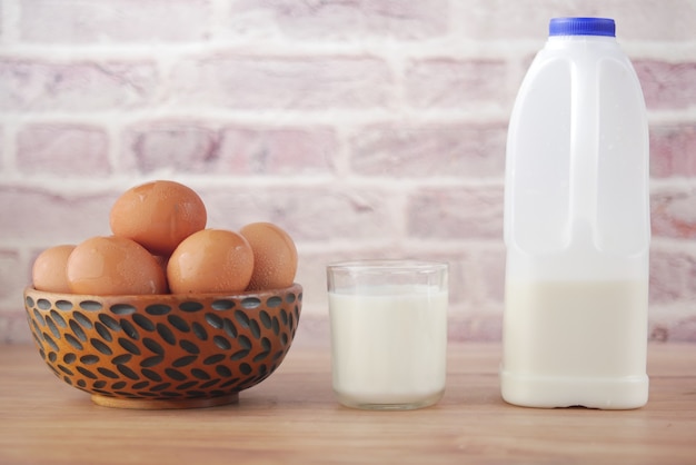 Photo oeufs dans un arc et un verre de lait sur la table