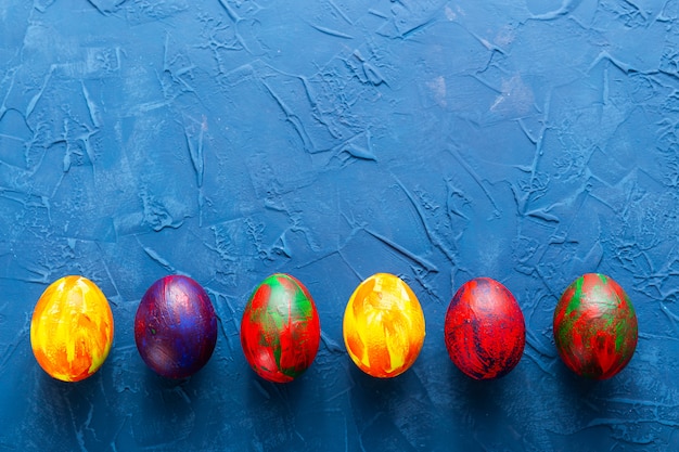 Oeufs décoratifs colorés sur fond bleu