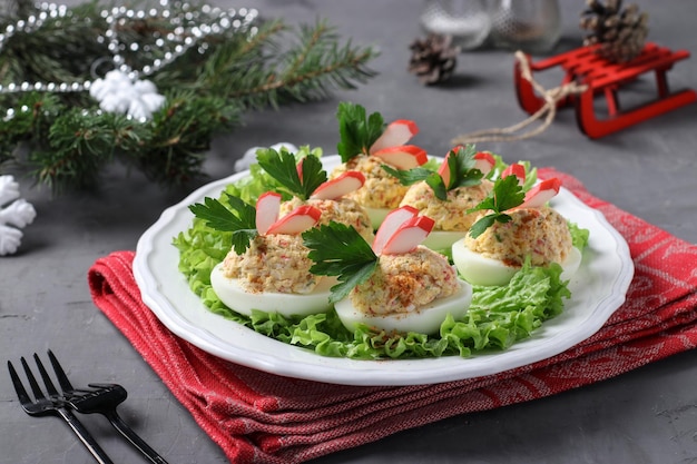 Photo oeufs farcis avec des bâtonnets de crabe et du fromage une délicieuse collation festive sur fond sombre gros plan