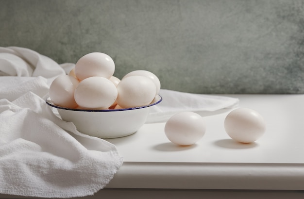 Oeufs frais dans un bol sur la table en bois