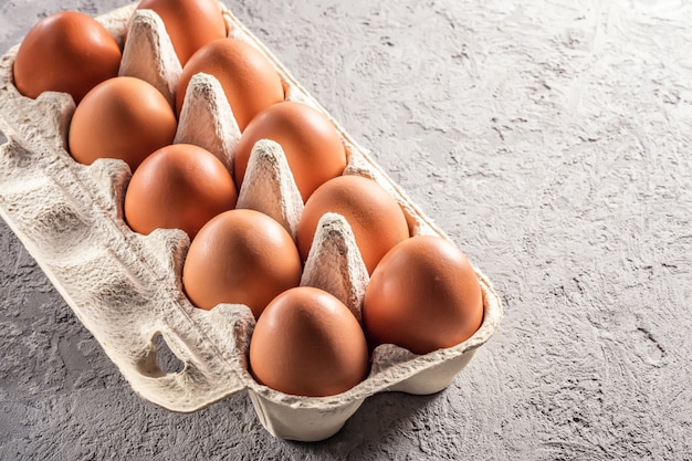 Photo oeufs frais de la ferme, emballage de la table grise, ingrédient de petit-déjeuner, préparation du petit-déjeuner, omelette aux oeufs brouillés