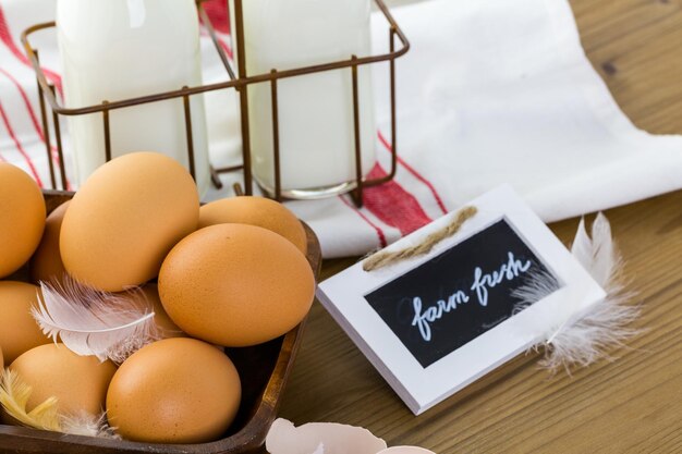 Oeufs frais de ferme, lait et beurre sur table en bois.