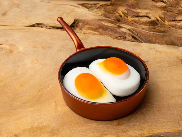 Oeufs frits à la poêle à jouets pour enfants sur un fond en bois isolé