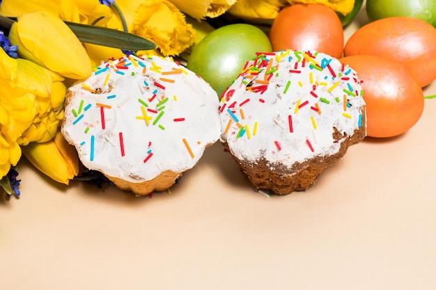 Oeufs de gâteaux de Pâques et tulipes jaunes sur fond beige