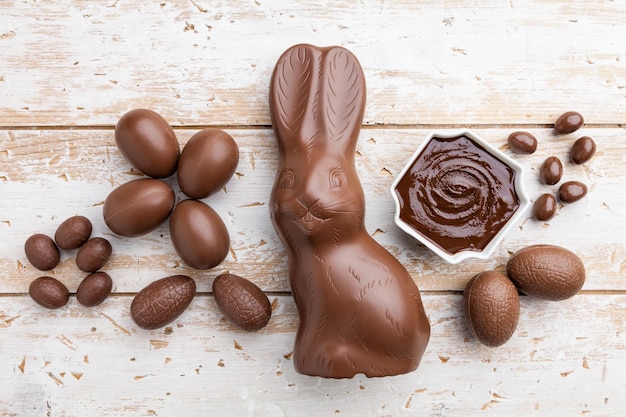 Oeufs de lapin de Pâques au chocolat et bonbons sur fond rustique