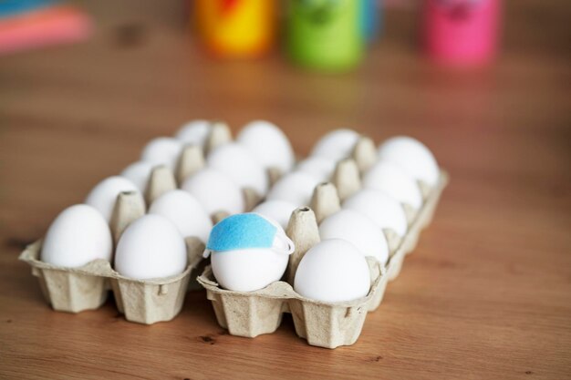 Oeufs avec masques dans une boîte en carton