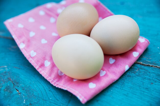 Oeufs sur nappe sur table en bois