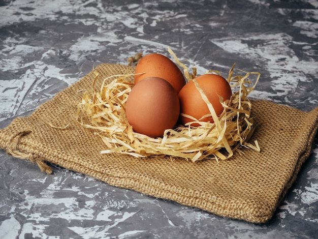 Oeufs en paille sur fond gris.