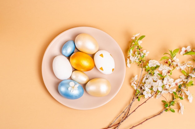 Oeufs de Pâques sur une assiette sur une surface beige avec copie espace