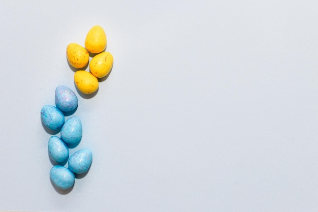 Oeufs de Pâques au chocolat bleu et jaune multicolores sur fond de papier