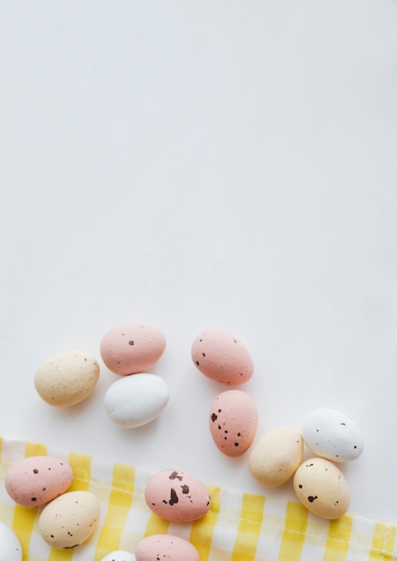 Oeufs de Pâques au chocolat sur un flatlay en tissu jaune