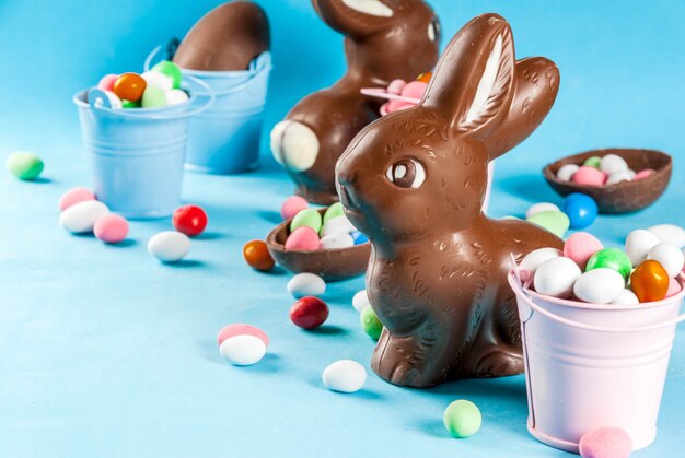 Oeufs de Pâques au chocolat, lapin et bonbons sur bleu clair, Pâques,