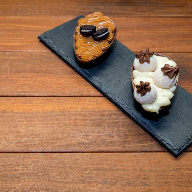 Oeufs de pâques au chocolat sur pierre noire avec fond en bois