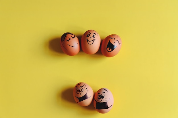 Oeufs de Pâques au poulet avec des visages de doodle portant des masques médicaux, des pilules sur fond jaune. Coronavirus