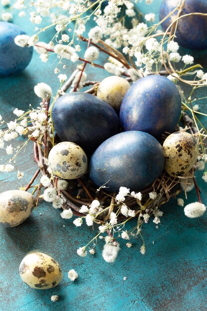 Oeufs de Pâques bleus dans un nid sur fond de pierre bleue ou d'ardoise xA