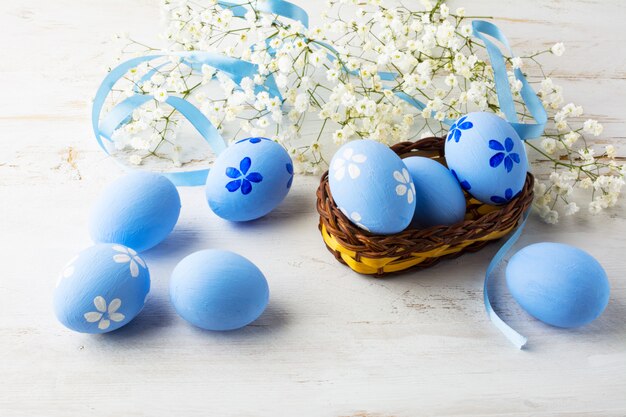Oeufs de Pâques bleus dans un petit panier en osier