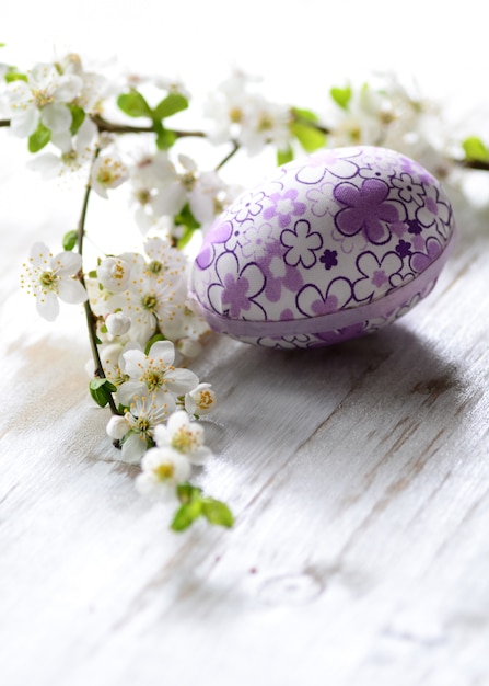 Oeufs de Pâques et branche avec des fleurs sur fond en bois