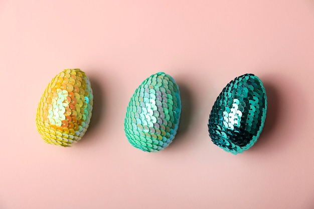 Oeufs de Pâques brillants colorés se trouvant dans la rangée sur le fond pastel Concept minimal Fond moderne