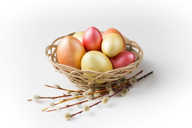 Oeufs de Pâques en bronze doré et rose avec saule dans le panier Élément de conception pour affiche ou bannière de cartes de voeux