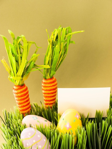 Oeufs de Pâques et carottes dans l'herbe.