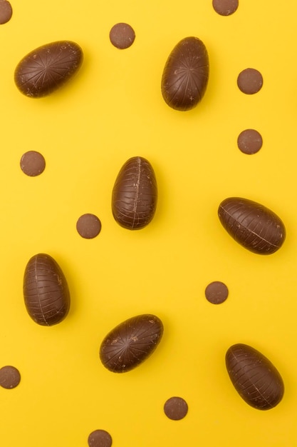 Oeufs de Pâques en chocolat sur fond jaune vif Concept de vacances de Pâques