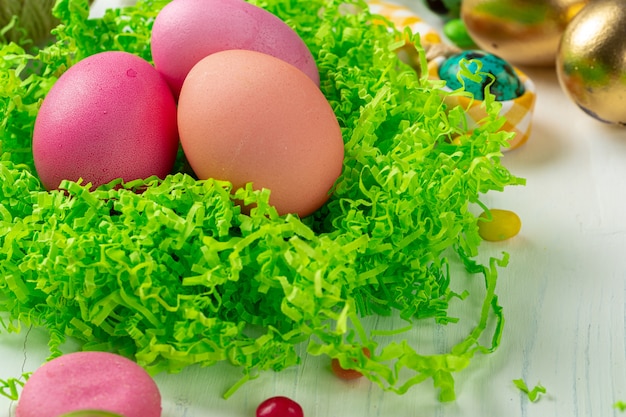 Oeufs de Pâques Colofrul et bonbons épars sur table en bois