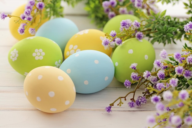 des œufs de Pâques colorés et une branche avec des fleurs