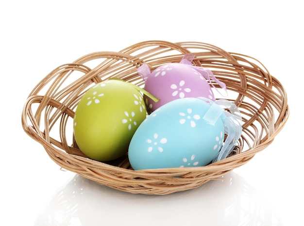 Oeufs de Pâques colorés dans le panier isolé sur blanc