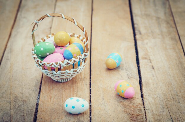 Oeufs de Pâques colorés dans le panier sur la table en bois gagner espace copie.