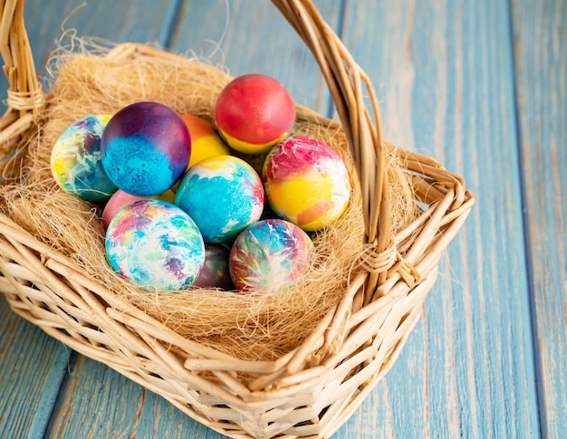 Photo oeufs de pâques colorés dans un panier