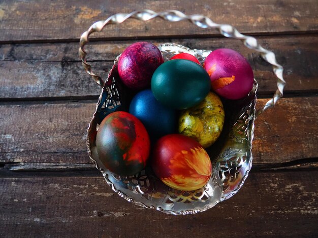 Oeufs de Pâques colorés dans un vieux bol de bonbons en métal sur une table en bois Pâques la résurrection du Christ la brillante résurrection du Christ la fête la plus ancienne et la plus chrétienne