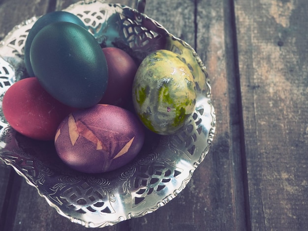 Oeufs de Pâques colorés dans un vieux bol de bonbons en métal sur une table en bois Pâques la résurrection du Christ la brillante résurrection du Christ la fête la plus ancienne et la plus chrétienne