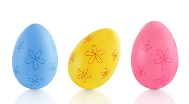 Des œufs de Pâques colorés avec des fleurs sur un fond blanc