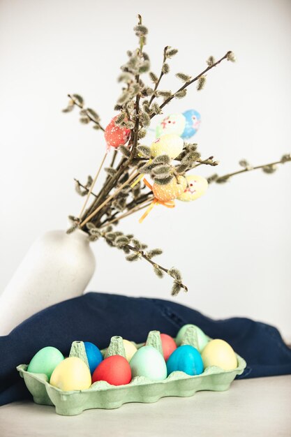 Oeufs de Pâques colorés avec des fleurs de printemps sur fond de bois Frontière de vacances d'oeufs colorés