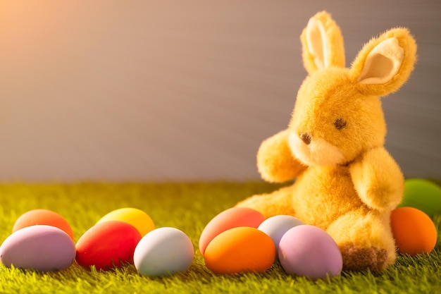 Oeufs de pâques colorés et jouet de lapin sur l'herbe verte