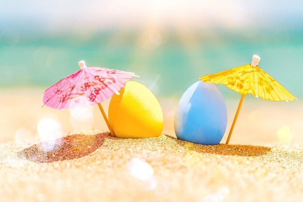 Oeufs de pâques colorés sur la plage de l'océan