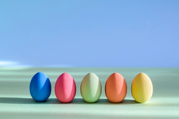 Oeufs de Pâques colorés sont debout dans une rangée