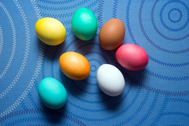 Oeufs de Pâques colorés sur une surface bleue