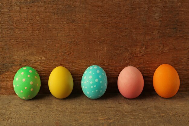 Oeufs de Pâques colorés sur une surface en bois