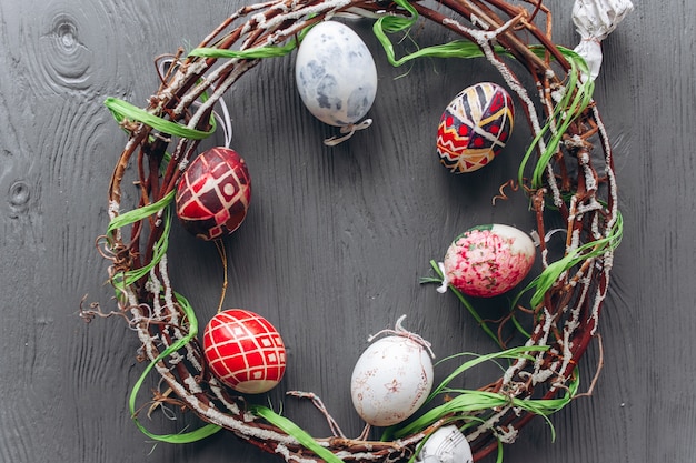 Oeufs de Pâques et une couronne sur un fond en bois